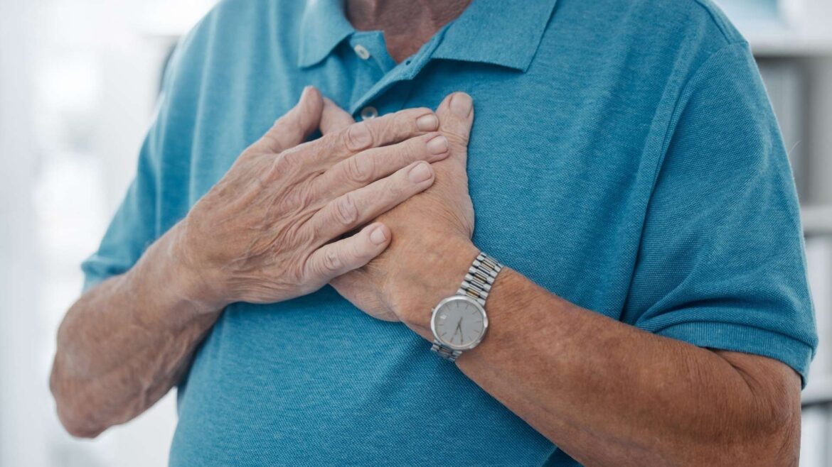 Homme âgé tenant ses deux mains sur sa poitrine